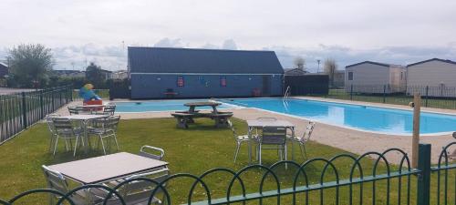 a swimming pool with tables and chairs in a yard at The Oyster Shell in Whitstable