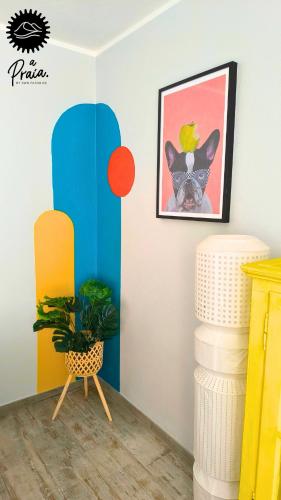 a room with a surfboard on the wall and a plant at A Praia My Own Paradise T2 1º Andar in Figueira da Foz