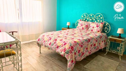 a bedroom with a bed and a blue wall at A Praia My Own Paradise T2 1º Andar in Figueira da Foz