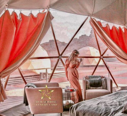 a woman standing in a tent in a bedroom at RUM SUNRlSE LUXURY CAMP in Wadi Rum