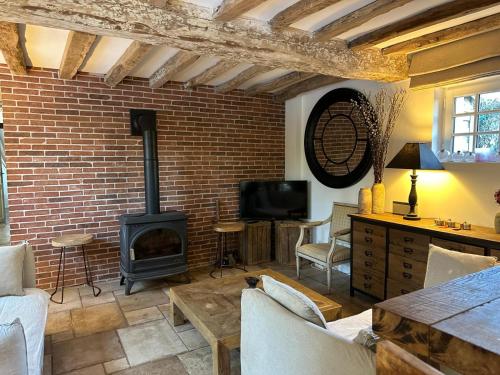 - un salon avec un mur en briques et un poêle à bois dans l'établissement Maison Pig House, à Varengeville-sur-Mer