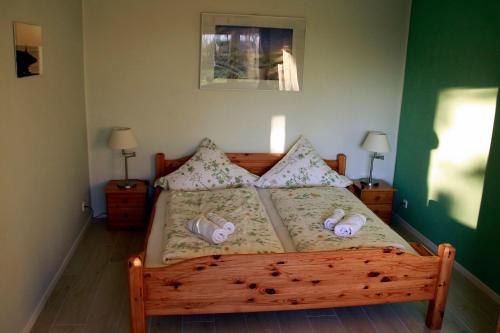 a bedroom with a wooden bed with slippers on it at Landhaus-Sutje-Im-Gruenen in St. Peter-Ording