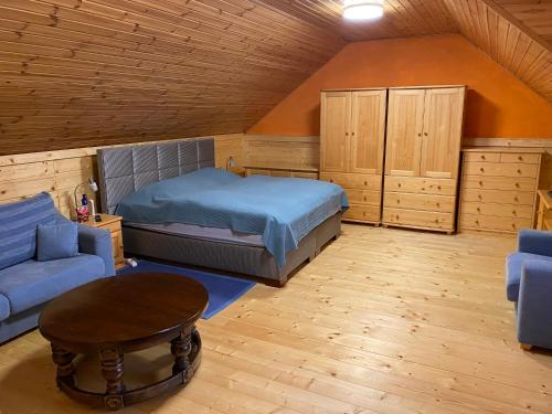 a bedroom with a bed and a couch and a table at Chalet Hronec in Hronec