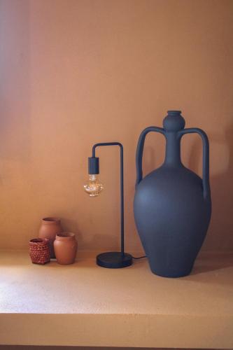 a blue vase sitting on a shelf next to a lamp at Antica Masseria le Monache in Grottaglie
