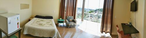 a bedroom with a bed and a balcony at Pousada Floresta in Joinville
