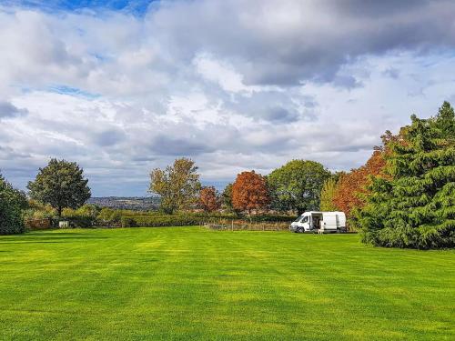biała ciężarówka zaparkowana na polu trawy w obiekcie WoodLands Basic Bell Tent 3 w mieście Grantham