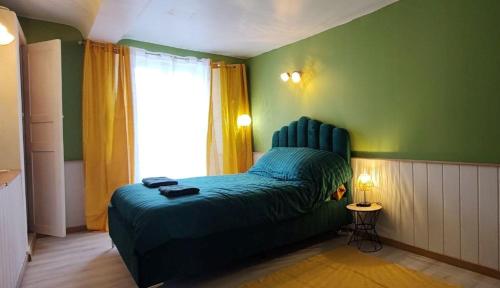 a bedroom with a bed in a green wall at Green Summer in Pont-d'Ouilly