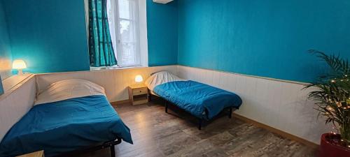 a bedroom with two beds and blue walls at Green Summer in Pont-d'Ouilly