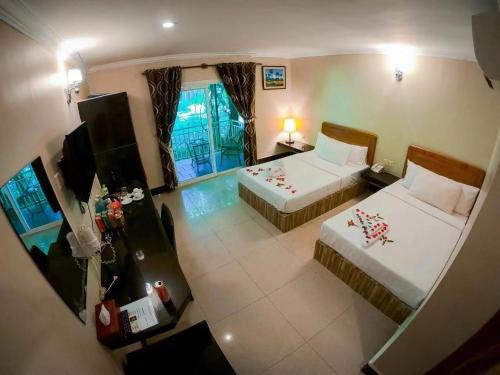 a hotel room with two beds and a television at Twin Palms Resort in Sihanoukville