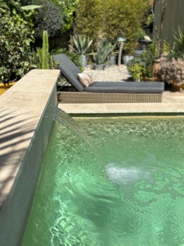 - une piscine avec une fontaine dans la cour dans l'établissement Logement cosy avec piscine ,parking et jardin, à Villeneuve-lès-Avignon