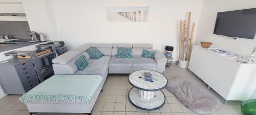 un salon avec un canapé et une table dans l'établissement Le Rayon de Soleil, à Mimizan