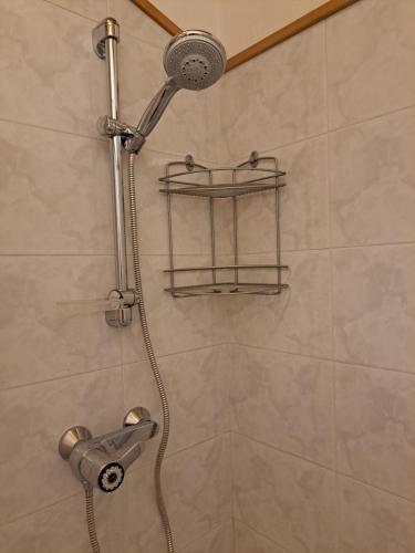 y baño con ducha con cabezal de ducha. en Cozy family apartment for rest and fun, en Sella Nevea