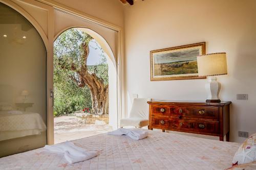 um quarto com uma cama e uma janela arqueada em Casa Ulivo em Orbetello