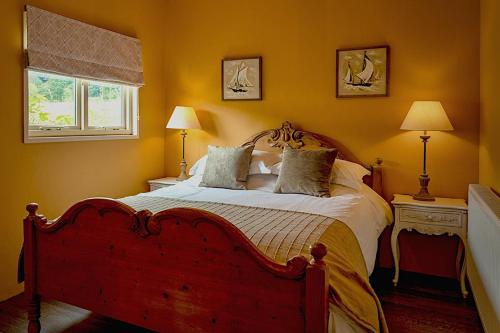 a bedroom with a large bed with yellow walls at The Artist's Studio in Kelling