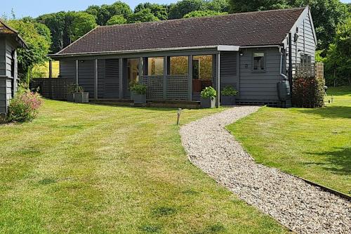 a small house with a gravel driveway in front of a yard at The Artist's Studio in Kelling