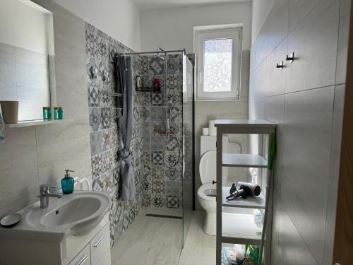 a bathroom with a toilet and a sink and a shower at Rosmarin Apartments Sea View Garden Side in Jadranovo