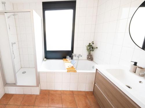 a white bathroom with a tub and a sink at Enjoy a 6-person bungalow in Zevenhuizen