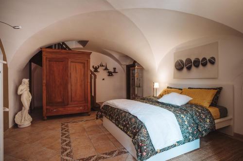 um quarto com uma cama num quarto com um tecto arqueado em Case vacanze in graziosa borgata alpina em Villaretto