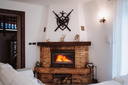 a living room with a fireplace with a clock on the wall at Case vacanze in graziosa borgata alpina in Villaretto