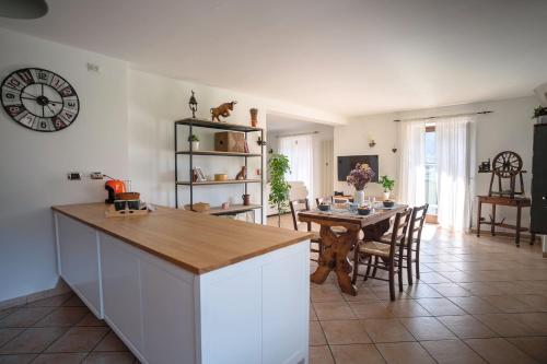 a kitchen and dining room with a table and a clock at Case vacanze in graziosa borgata alpina in Villaretto