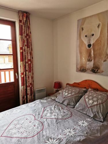 - une chambre dotée d'un lit avec une photo d'un ours sur le mur dans l'établissement Reflets montagnards, à Vignec