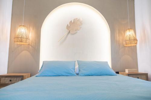 a bedroom with a blue bed with a clock on the wall at La Casa a Zia in Lagoúdi Zía