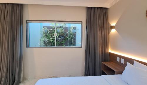 a bedroom with a window with plants in it at Pousada Marítimos in Maragogi