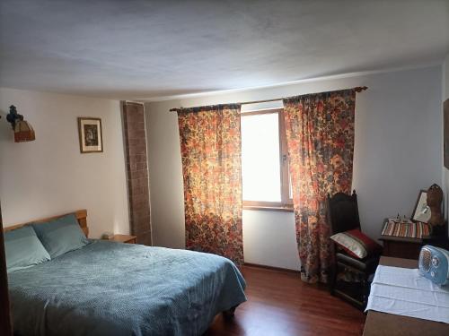 ein Schlafzimmer mit einem Bett, einem Fenster und einem Stuhl in der Unterkunft Cabana Țibleș 