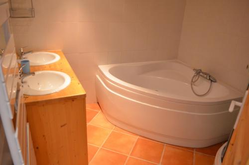 une salle de bain avec deux lavabos et une baignoire dans l'établissement chez Gaëlle et Martin, à Saint-Vincent-de-Barrès