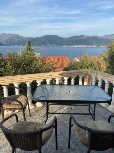 a table and chairs on a balcony with a view of the water at Apartments Arina in Krasici