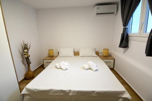a bedroom with a bed with white sheets and pillows at Blue Lagoon 1 in Kavala