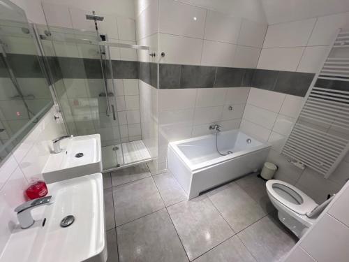 a bathroom with a toilet and a tub and a sink at L8 Street Monteurwohnung - Mönsheim in Mönsheim