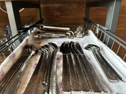 a group of forks and spoons in a dishwasher at Woodland camping pod with use of campsite bathroom in Grantham