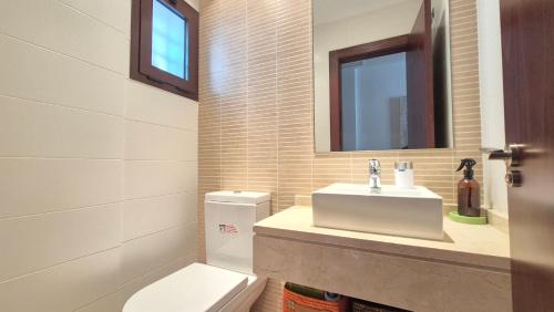 bagno con servizi igienici, lavandino e specchio di Apartamento en Los Monteros a Marbella