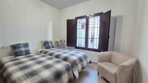 una camera con un letto e una sedia e una finestra di Apartamento en Los Monteros a Marbella
