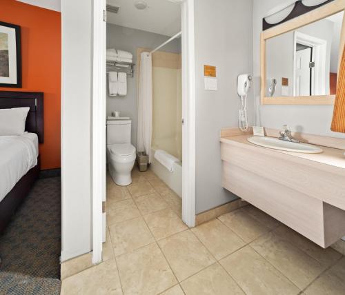 a bathroom with a bed and a sink and a toilet at BCMInns - Coleman in Coleman