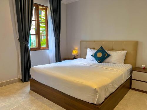 a bedroom with a large bed with a window at Sea Sunset Hotel Phu Quoc - Welcome to a mixing world of friends in Phu Quoc