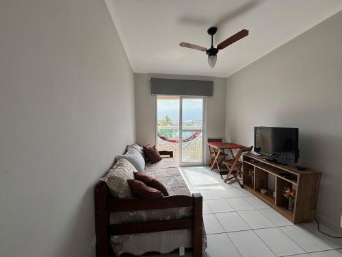 a living room with a couch and a flat screen tv at Apto dos Cardeais in Praia Grande
