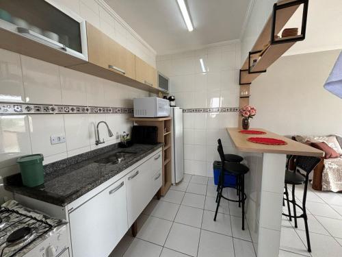 a small kitchen with a sink and a table at Apto dos Cardeais in Praia Grande