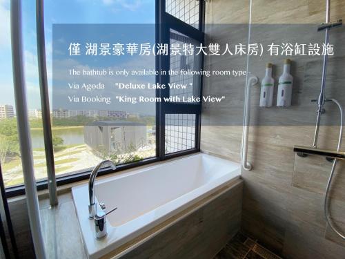 a bath tub in a bathroom with a window at alfar Hotel in Dayuan
