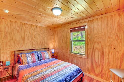 1 dormitorio con 1 cama en una habitación de madera en Serene Beattyville Cabin 24 Mi to Red River Gorge en Beattyville