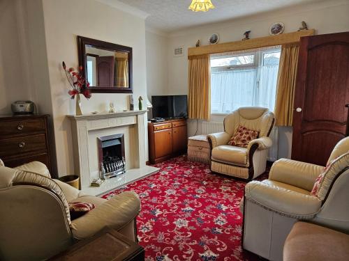 a living room with two chairs and a fireplace at Broughton Grove - Skipton, Pet Friendly, Canal Access in Skipton