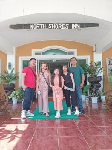a group of people standing in front of a building at North Shores Inn in Currimao