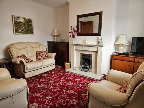 a living room with two chairs and a fireplace at Broughton Grove - Skipton, Pet Friendly, Canal Access in Skipton