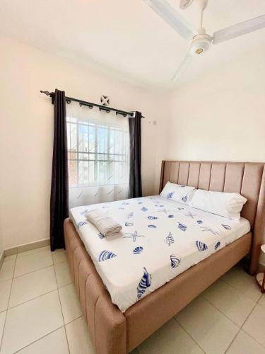 a bed in a room with a window at Pazuri Homes 2BD Apartment in Mombasa