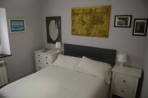 Un dormitorio con una cama blanca y un mapa en la pared en La Casina de Luarca, en Luarca