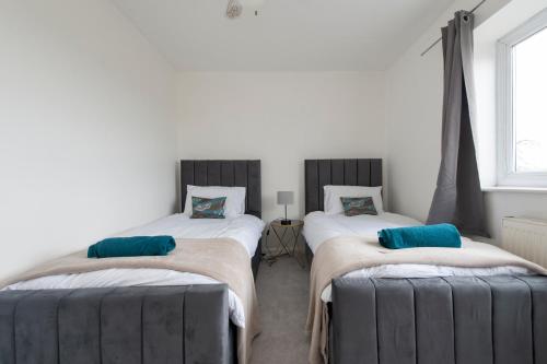 2 aparte bedden in een kamer met een raam bij Chingford charm great for families and contractors in Ponders End