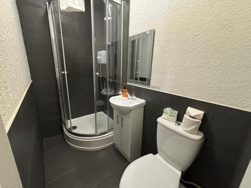 a bathroom with a shower and a toilet and a sink at Clarin Guest House in Edinburgh
