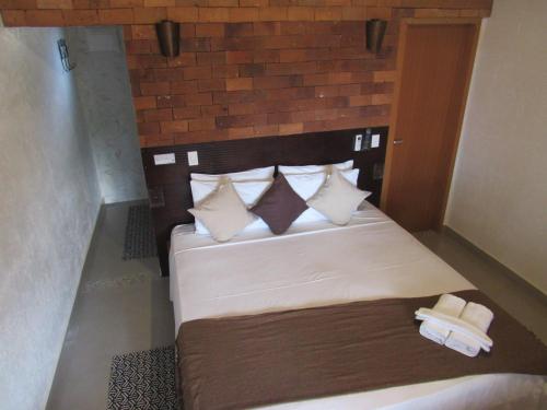 a bedroom with a large bed with white sheets and pillows at Pousada Meraki in Serra do Cipo