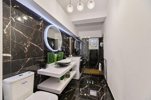 a bathroom with a sink and a toilet and a mirror at AYASI Luxury Apartment Predeal in Predeal